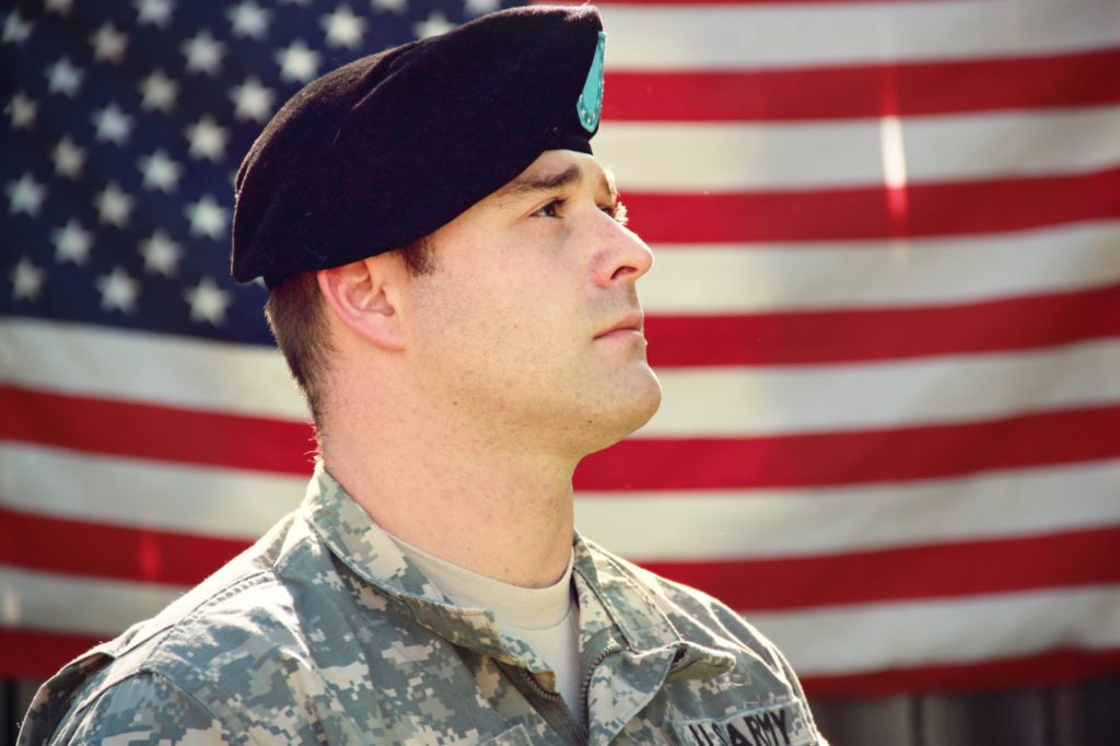 A man standing in front of a flag