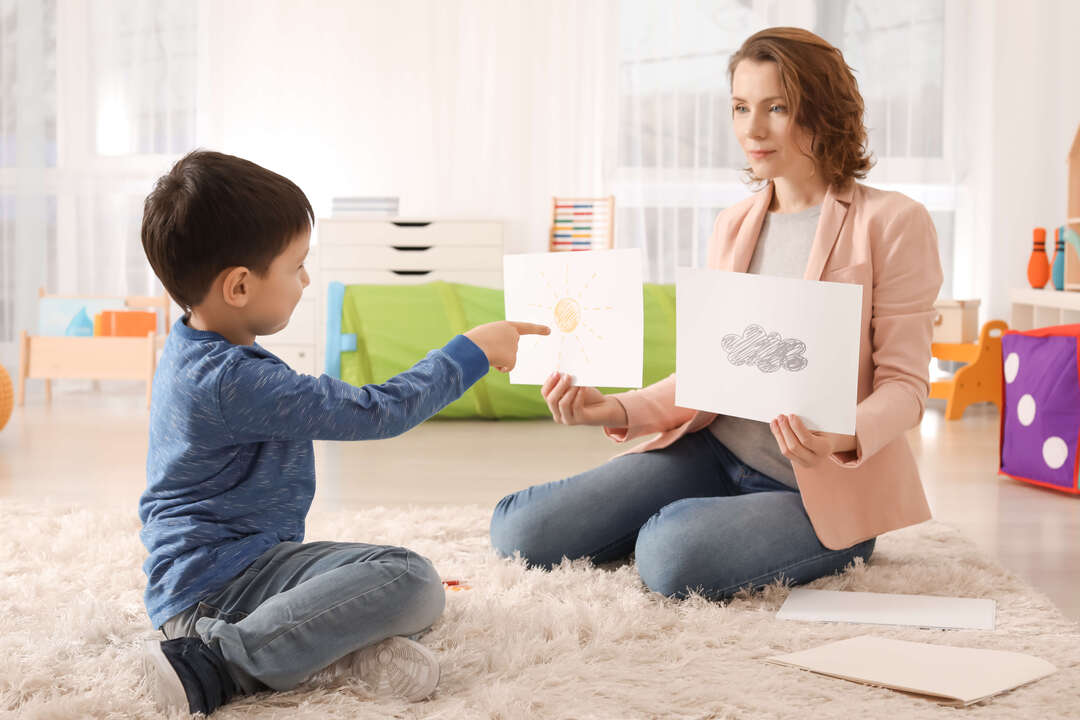 Female psychologist working with boy suffering from autistic disorder